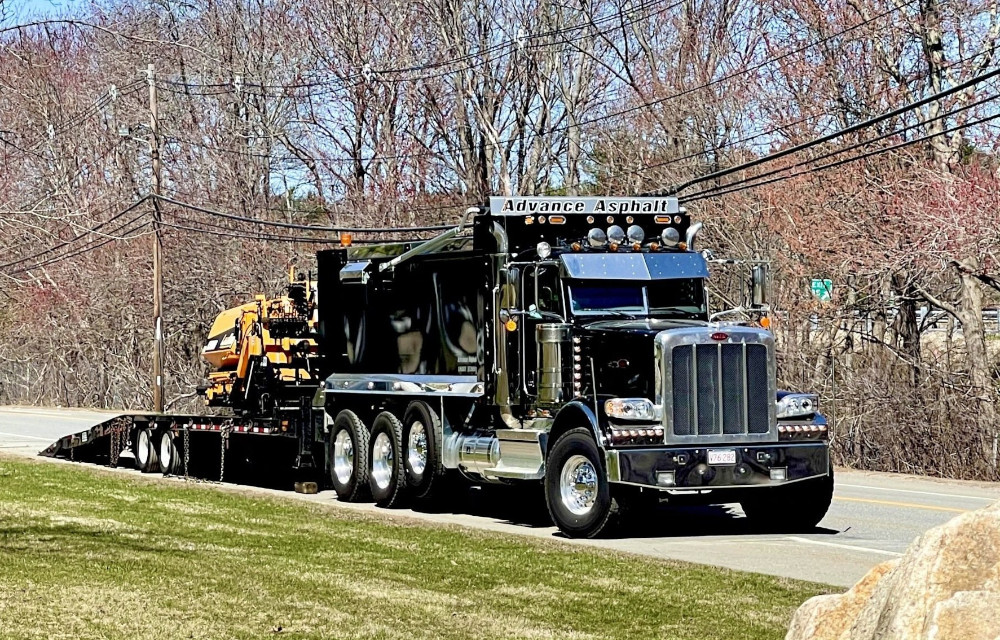 A truck driving on a road in Plymouth, MA, after residential paving services